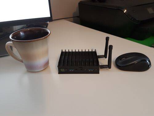 El Mintbox Mini 2 al lado de una taza de café.